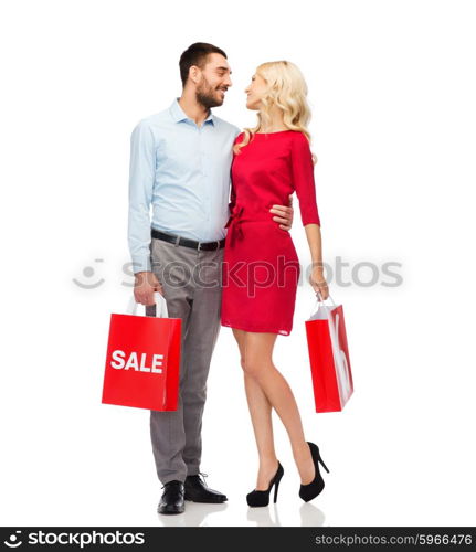 people, sale, discount and holidays concept - happy couple hugging with red shopping bags