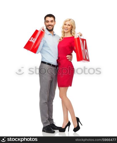 people, sale, discount and holidays concept - happy couple hugging with red shopping bags
