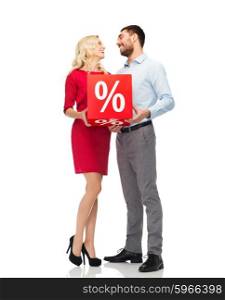 people, sale, discount and holidays concept - happy couple with red sale sign