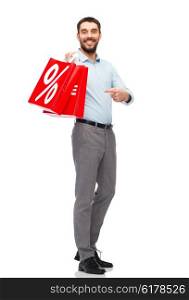 people, sale, discount and holidays concept - smiling man holding red shopping bags with percentage sign