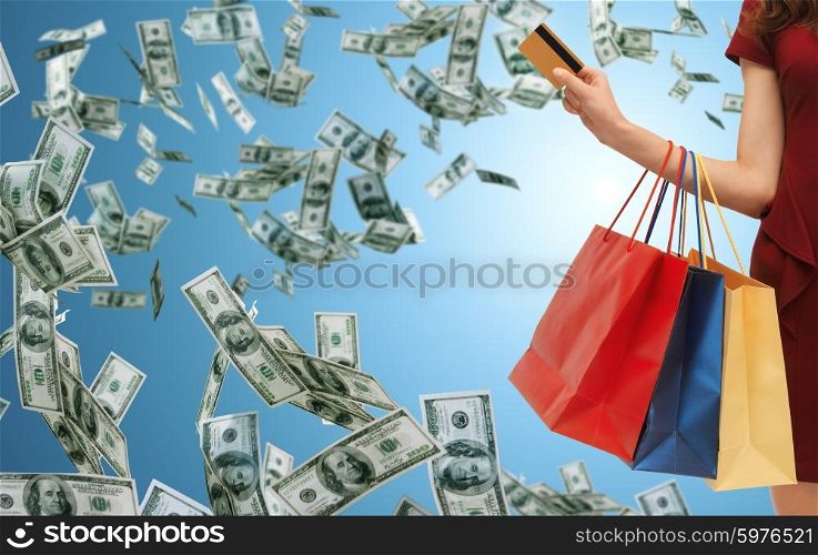 people, sale, finance and consumerism concept - close up of woman with shopping bags and bank or credit card over blue background and money rain
