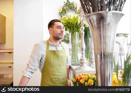 people, sale, retail, business and floristry concept - happy florist man with cashbox standing at flower shop