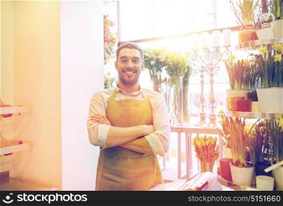 people, sale, retail, business and floristry concept - happy smiling florist man or seller standing at flower shop counter. florist man or seller at flower shop counter