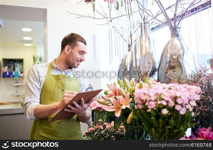 people, sale, retail, business and floristry concept - happy smiling florist man with clipboard writing and making notes order at flower shop