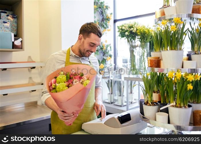 people, sale, retail, business and floristry concept - happy smiling florist man with bunch counting cost at flower shop cashbox