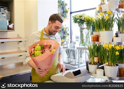 people, sale, retail, business and floristry concept - happy smiling florist man with bunch counting cost at flower shop cashbox