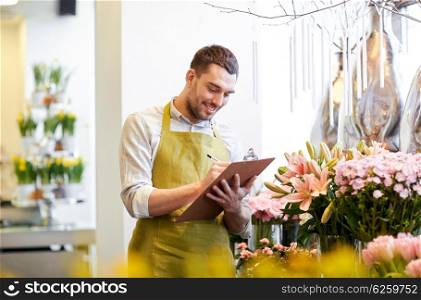 people, sale, retail, business and floristry concept - happy smiling florist man with clipboard writing and making notes order at flower shop