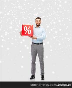 people, sale, shopping, christmas and winter holidays concept - smiling man holding red percentage sign over snow background