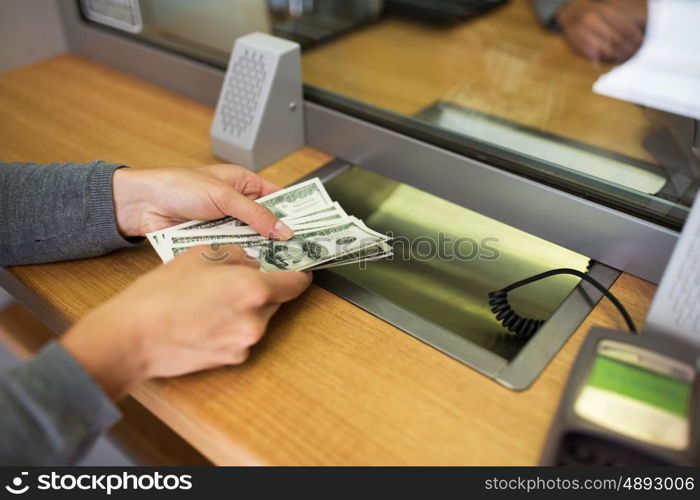 people, saving, cash, withdrawal and finance concept - customer hands with money at bank office or currency exchanger