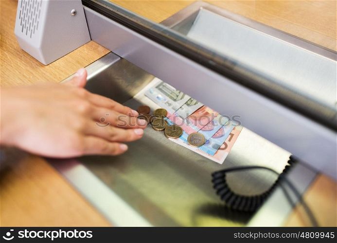 people, saving, currency exchange, withdrawal and finance concept - hand with cash money at bank office