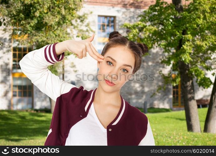 people, school, education, stress and teens concept - bored teenage student girl making headshot by finger gun gesture over summer campus background
