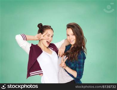 people, school, education, teens and friends concept - happy smiling pretty teenage student girls showing peace hand sign over green chalk board background