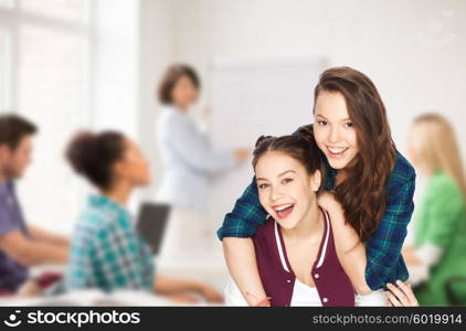 people, school, education, teens and friendship concept - happy smiling pretty teenage student girls having fun over classroom background with teacher and classmates