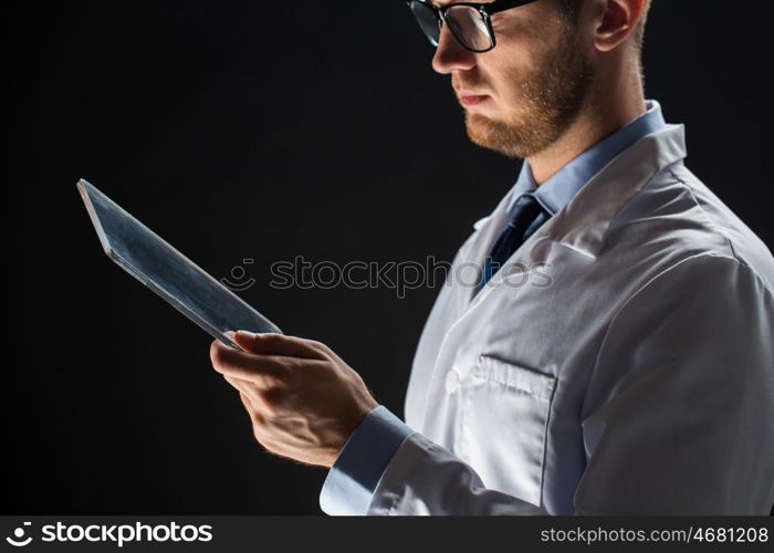 people, science, technology and medicine concept - close up of male doctor or scientist in white coat with tablet pc computer over black background