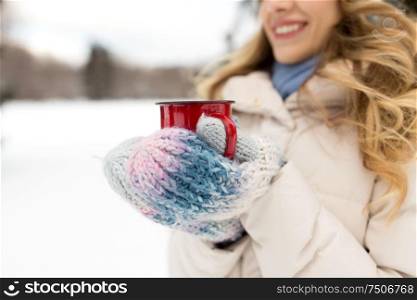people, season and christmas concept - close up of happy young woman with tea cup outdoors in winter park. happy young woman with tea cup in winter park