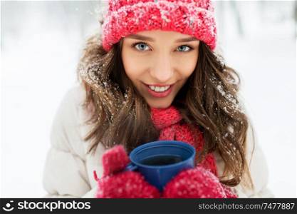 people, season and christmas concept - happy teenage girl or young woman with tea cup outdoors in winter. happy young woman with tea cup in winter