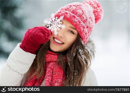 people, season and christmas concept - portrait of happy smiling teenage girl or young woman with snowflake in winter park. portrait of teenage girl with snowflake in winter