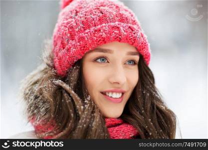 people, season and christmas concept - portrait of happy smiling teenage girl or young woman outdoors in winter park. smiling teenage girl outdoors in winter