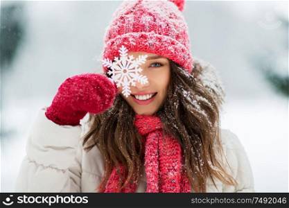 people, season and christmas concept - portrait of happy smiling teenage girl or young woman with snowflake in winter park. portrait of teenage girl with snowflake in winter