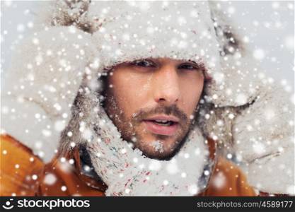 people, season and leisure concept - face of man in winter clothes outdoors