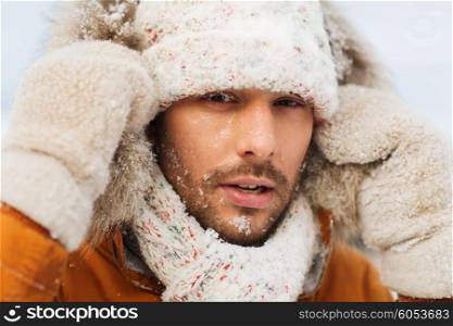 people, season and leisure concept - face of man in winter clothes outdoors