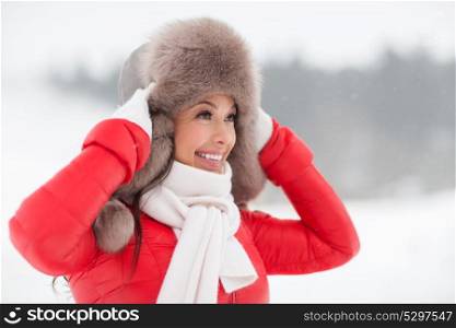 people, season and leisure concept - happy smiling woman in winter fur hat outdoors. happy smiling woman in winter fur hat outdoors