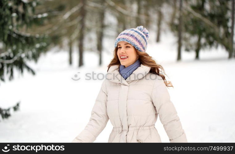 people, season and leisure concept - happy smiling woman outdoors in winter forest. happy smiling woman outdoors in winter forest