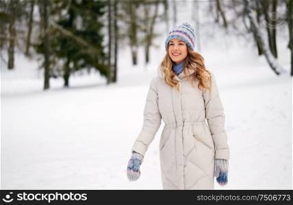 people, season and leisure concept - happy smiling woman outdoors in winter forest. happy smiling woman outdoors in winter forest