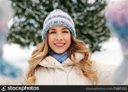 people, season and leisure concept - happy smiling woman taking selfie outdoors in winter. smiling woman taking selfie outdoors in winter