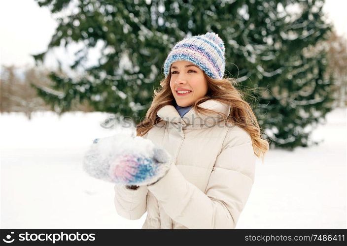 people, season and leisure concept - happy smiling woman with snow in winter forest. smiling woman with snow in winter forest