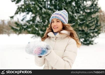 people, season and leisure concept - happy smiling woman with snow in winter forest. smiling woman with snow in winter forest