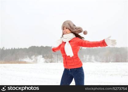 people, season and leisure concept - happy woman in winter fur hat having fun outdoors. happy woman in winter fur hat having fun outdoors