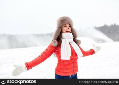 people, season and leisure concept - happy woman in winter fur hat having fun outdoors. happy woman in winter fur hat having fun outdoors