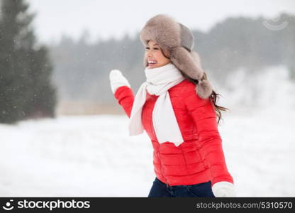 people, season and leisure concept - happy woman in winter fur hat having fun outdoors. happy woman in winter fur hat outdoors