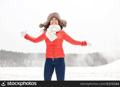 people, season and leisure concept - happy woman in winter fur hat having fun outdoors. happy woman in winter fur hat having fun outdoors