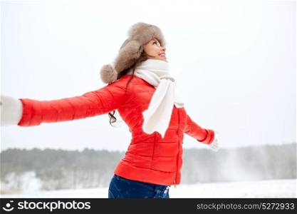 people, season and leisure concept - happy woman in winter fur hat outdoors. happy woman in winter fur hat outdoors