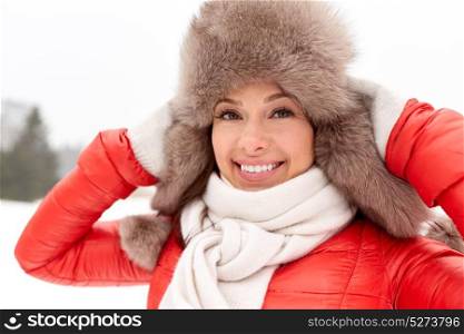 people, season and leisure concept - happy woman in winter fur hat outdoors. happy woman in winter fur hat outdoors