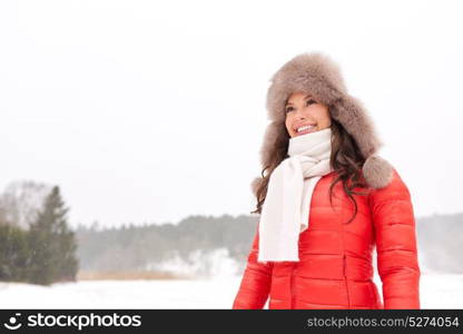 people, season and leisure concept - happy woman in winter fur hat outdoors. happy woman in winter fur hat outdoors