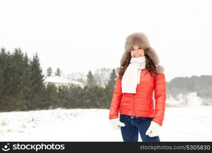 people, season and leisure concept - happy woman in winter fur hat outdoors. happy woman in winter fur hat outdoors