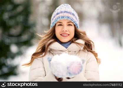people, season and leisure concept - portrait of happy smiling woman with snow in winter forest. portrait of woman with snow in winter forest