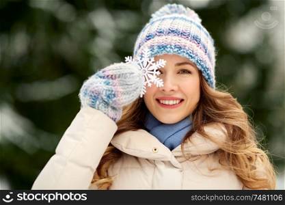 people, season and leisure concept - portrait of happy smiling woman with snowflake in winter forest. portrait of woman with snowflake in winter