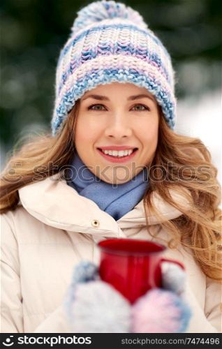 people, season, drinks and leisure concept - close up of happy young woman with tea cup outdoors in winter. happy young woman with tea cup outdoors in winter