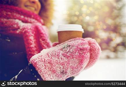 people, season, drinks and leisure concept - close up of woman hand with coffee cup outdoors in winter. close up of hand with coffee outdoors in winter