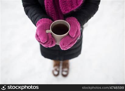 people, season, drinks and leisure concept - close up of woman with tea mug outdoors in winter