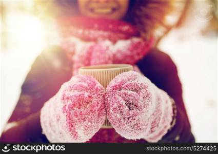 people, season, drinks and leisure concept - close up of woman with tea mug outdoors in winter. close up of woman with tea mug outdoors in winter