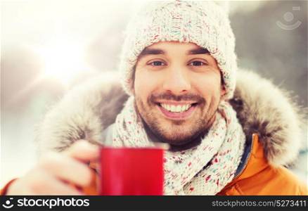 people, season, drinks and leisure concept - happy man with tea cup outdoors in winter. happy man with tea cup outdoors in winter