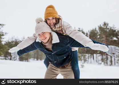 people, season, love and leisure concept - happy couple having fun in winter park. happy couple having fun in winter park