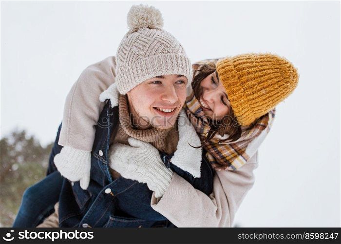 people, season, love and leisure concept - happy couple having fun in winter park. happy couple having fun in winter park