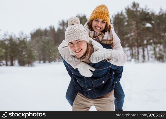 people, season, love and leisure concept - happy couple having fun in winter park. happy couple having fun in winter park