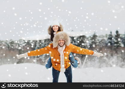 people, season, love and leisure concept - happy couple having fun over winter background